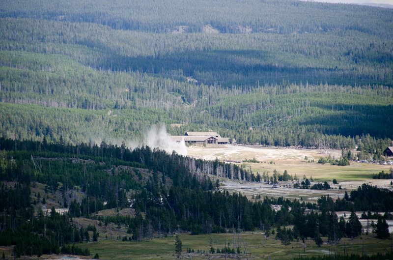 _DSC7271.jpg - Old Faithful erupting in front of Old Faithful Lodge (3 miles away) seen from the overlook on the Mystic Falls Loop Trail